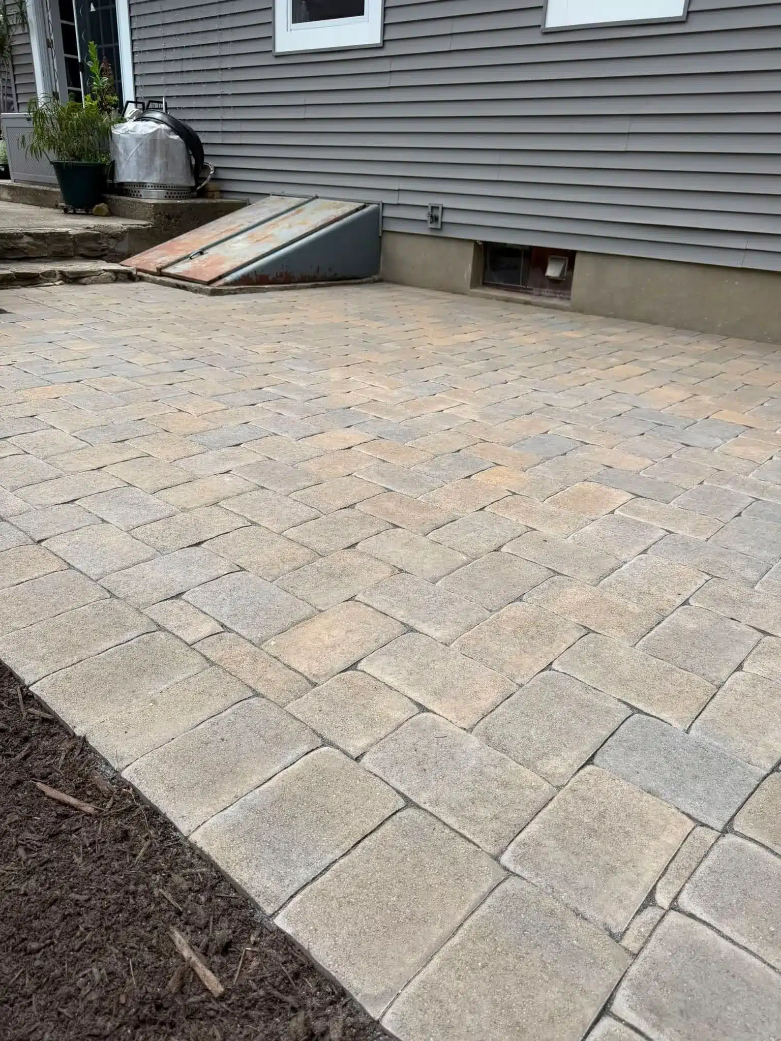 Herringbone-pattern Yankee Cobble paver installation enhancing a Groton, CT landscape by Spicer’s Lawn Care & Landscape Design.